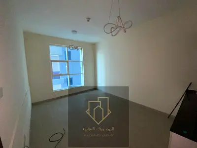 Spacious one-bedroom apartment with living room and open kitchen, featuring an open view towards Sharjah, no parking, and offered at a bargain price.