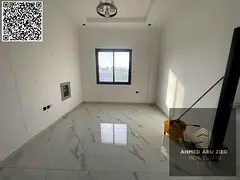 For annual rent in Ajman, a new building offers a two-bedroom apartment with a living room, three ba