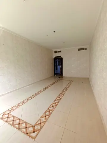 For rent in Al Taawun: 2BR + hall & living area, free central AC, free gym & pool, prime location near Al Taawun roundabout & Dubai exit.