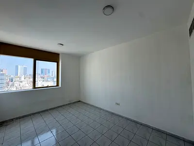 For rent: a two-bedroom apartment with a living room, two bathrooms, and a balcony. Spacious areas and a prime location near Ajman Corniche and on a m