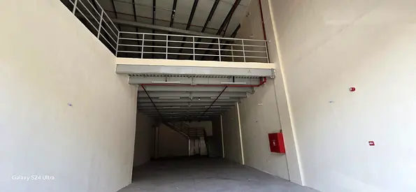 فرصة ذهبية! مستودع كبير بمساحة 4400 قدم مربع مع طابق نصفي متاح للإيجار في منطقة الجرف الصناعية 1