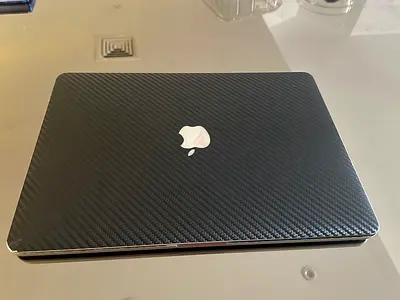 MacBook Pro (15-inch, Mid 20215) with carbon fibre case.