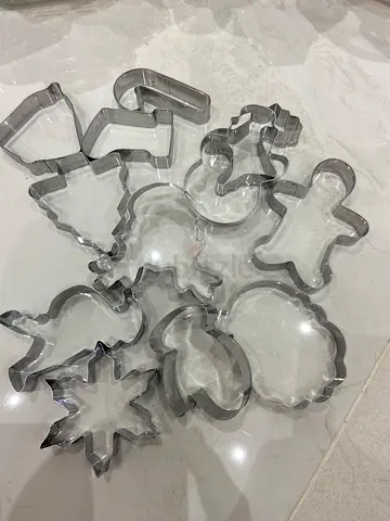 A set of metal cookie cutters typically used for baking gingerbread or holiday cookies. Material: St
