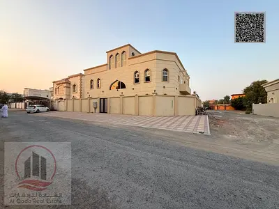 Villa for sale in Ajman, Al Muwaihat area, 12 master bedrooms, a majlis, 6 living rooms, and a maid's room. Freehold for all nationalities. Bank finan