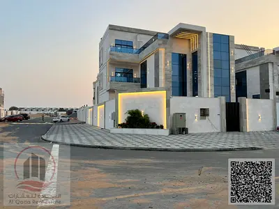 Corner villa for sale in Ajman, Al Helio area. 6 master bedrooms, majlis, living room, swimming pool, and roof terrace. The villa has an elevator and