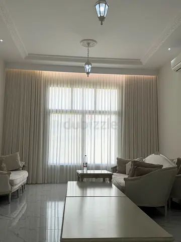 Elegant Living Room with Stylish Light Fixtures and Curtains
