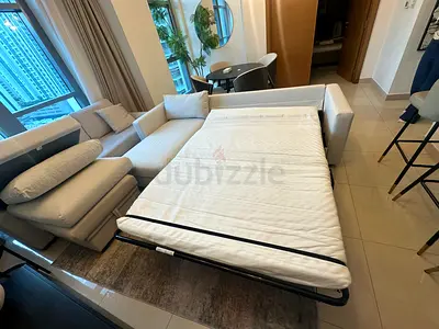 Cream color sofa bed with durable frame and soft fabric.