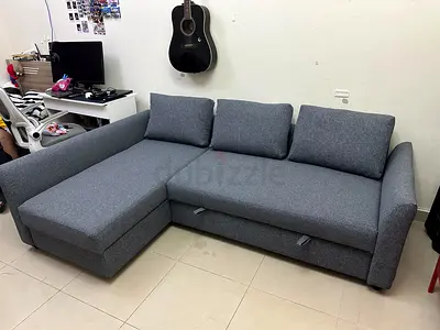 Elegant Grey L-Shape Sofa Bed. Durable fabric and spacious storage for blankets and pillows.