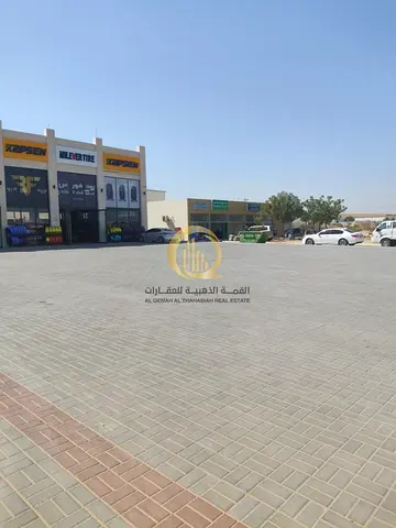 Land for sale in Al-Sajaa Industrial Area, with an area of 7,600 sq ft, located on a corner with two 24-meter streets