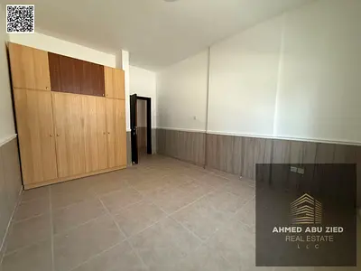 Largest one-bedroom apartment for annual rent in Al Rawda 2, Ajman – Master bedroom with balcony and built-in wardrobes, close to all services