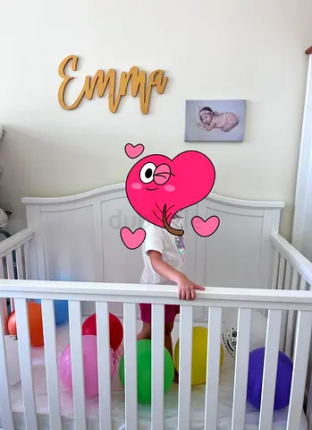 White baby crib with mattress and bed sheets