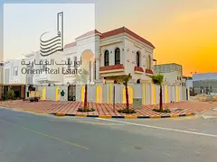 Corner villa for sale in Ajman, Al Helio 2 area, consisting of 5 master bedrooms, a living room, and