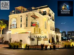 In Al Bahia area, Ajman, a corner villa with two floors and a roof, fully air-conditioned, freehold