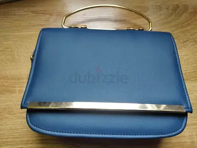 Elegant blue clutch bag with gold handle