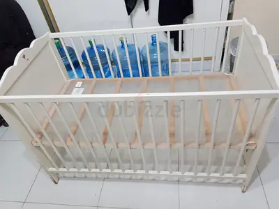 White wooden baby crib — slatted frame, mattress included