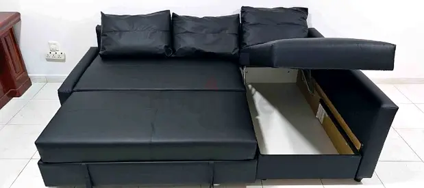 Black L-shaped faux leather sofa bed with storage and pull-out bed