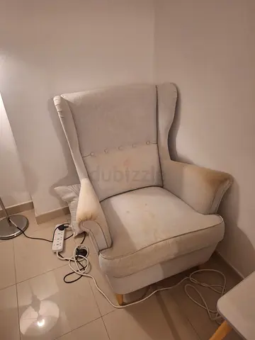 Beige wingback armchair, used — some fabric stains