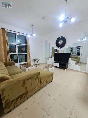 Furnished one-bedroom apartment for rent in Ajman with a living room, prime location on Khalifa Street next to Safir Mall and opposite Grand Mall, inc