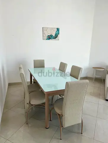 Glass-top 6-seater dining table with upholstered chairs
