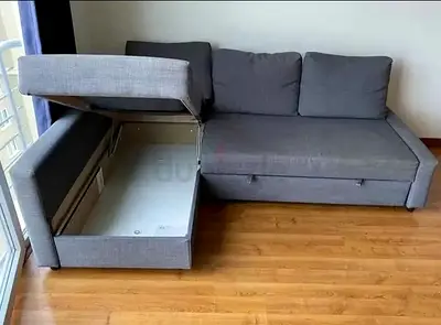 Grey L-shaped sofa bed with storage — pull-out  chaise