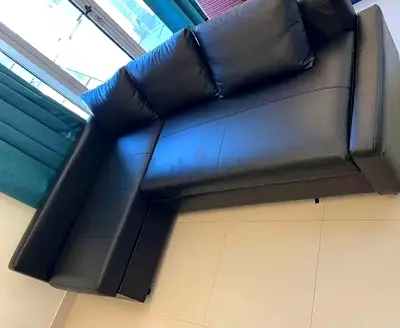 My L-shaped black faux leather sofa bed- good condition