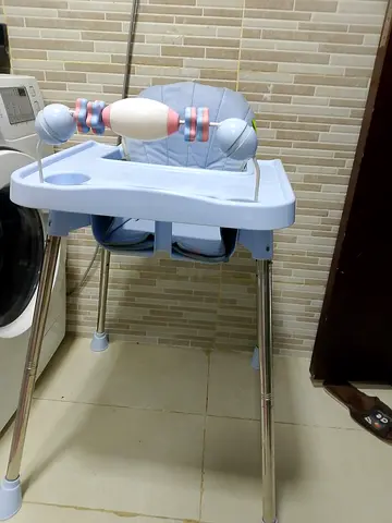 Light blue baby high chair with removable tray and toy bar