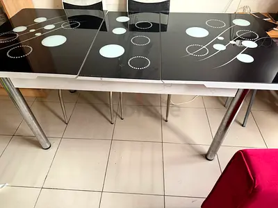 Used black glass dining table with metal legs