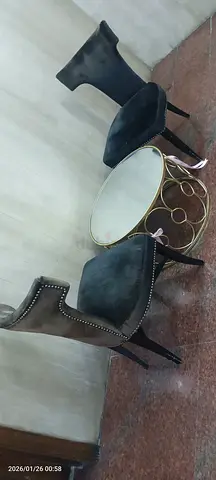 Two black velvet accent chairs with round gold coffee table