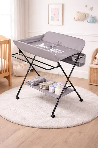 gray folding baby changing table with storage shelf