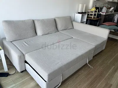 L-shaped light beige fabric sofa bed with chaise