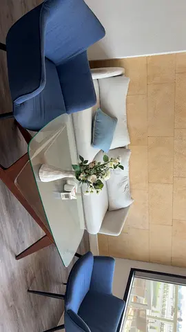 Light grey 2-seater sofa with glass coffee table and two blue armchairs