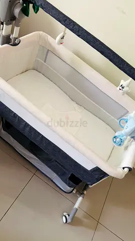 Portable bedside bassinet (co-sleeper) - gray/cream and automatic rocking, good condition.