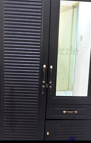 Dark louvered wardrobe with mirror and lockable drawers