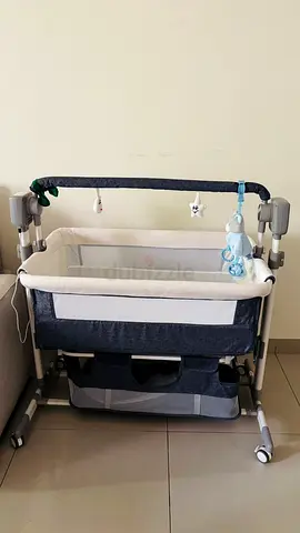Portable bedside bassinet (co-sleeper) - gray/cream and automatic rocking, good condition.