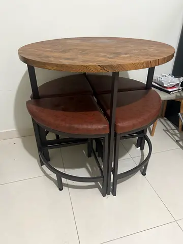 My round wood-top table with four brown leather stools — compact set