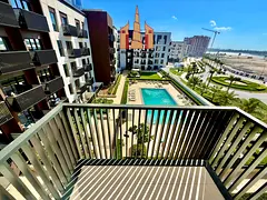 Experience upscale living in a luxurious community – stylish balcony with serene pool views, top-c