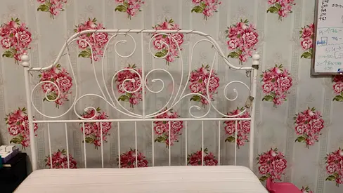 White metal vintage-style double bed frame with decorative headboard