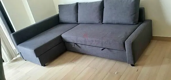 Grey L-shaped sofa bed with chaise and under-seat storage — good condition