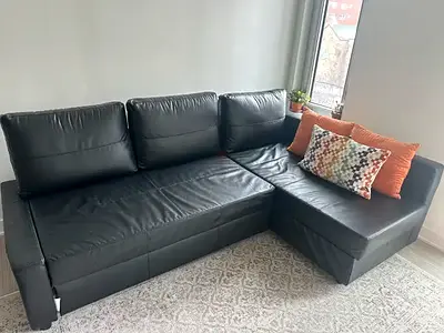 Black L-shaped leather-effect sofa with chaise (right)
