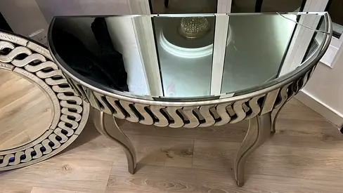 Mirrored half-moon console table with decorative trim