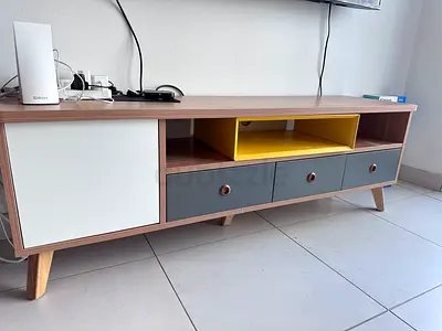 Low TV unit — wood finish with 3 drawers and yellow accent
