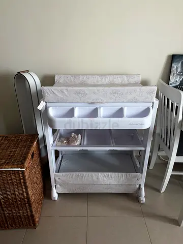 White changing table with storage bins, removable changing pad and baby bath inside