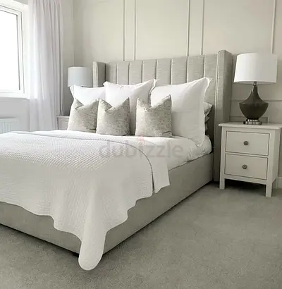 Light grey upholstered bed frame with tall panel headboard