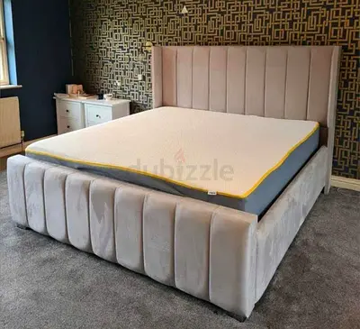 Light grey upholstered velvet bed frame with tall padded headboard