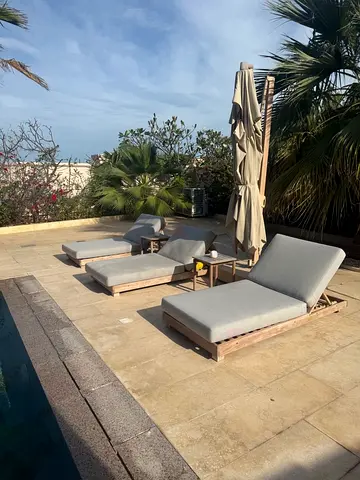 Three luxury sunbeds with two side tables and umbrella