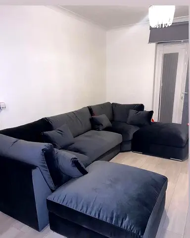 L-shaped dark grey velvet sectional sofa with ottoman