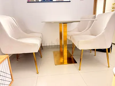 White marble-top dining set with 4 cream upholstered chairs (gold legs)