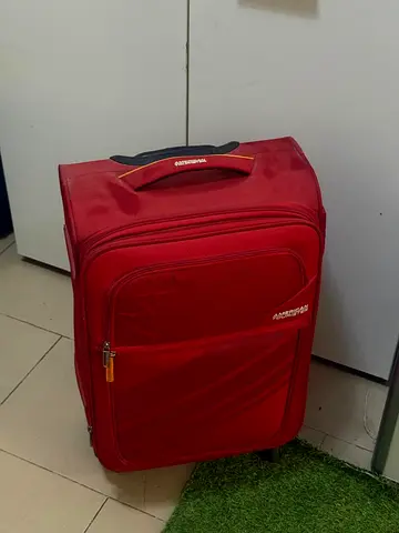 American Tourister medium red roller luggage - good used condition