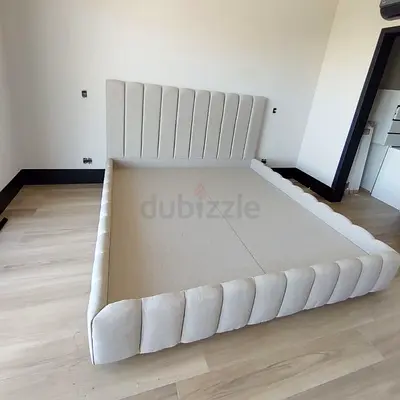 Light beige upholstered bed frame with padded headboard