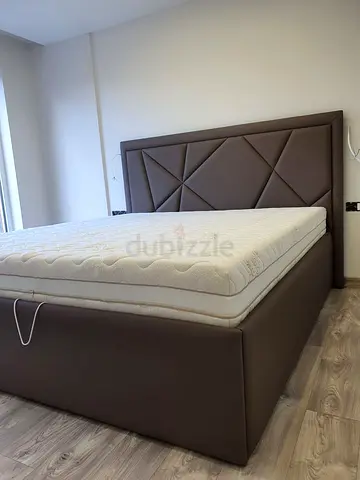 Brown upholstered storage bed with geometric headboard